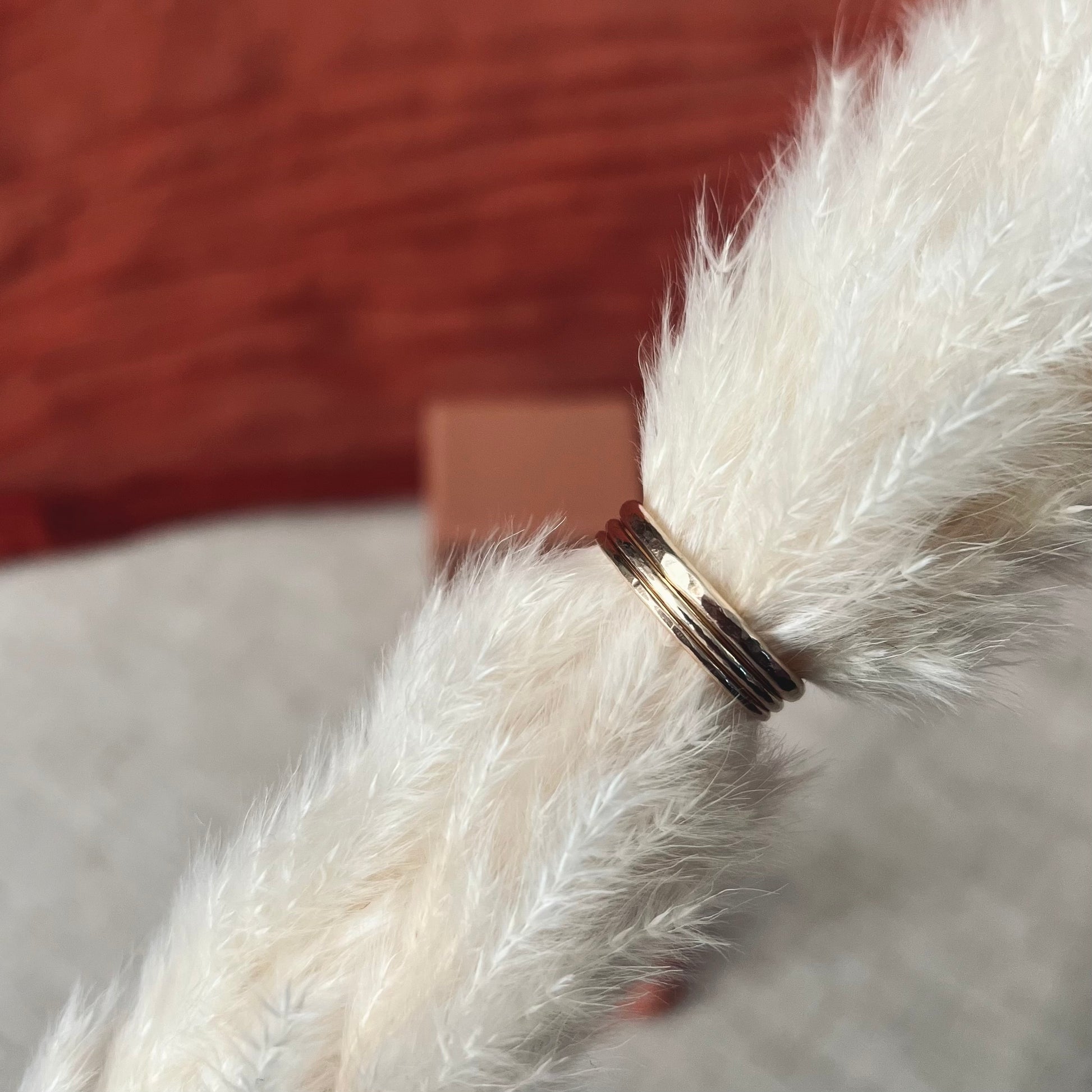 three different sizes of golden rings on dried flowers