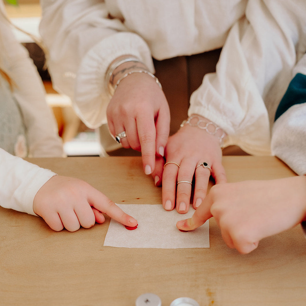 Two people examining a small object on a wooden table
