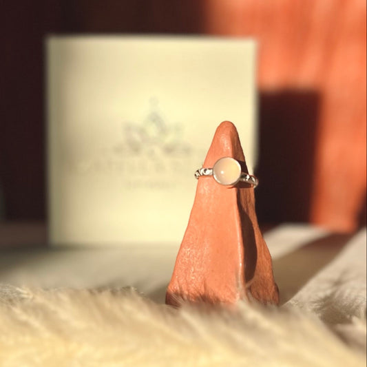Silver ring on a wooden stand with a blurred background